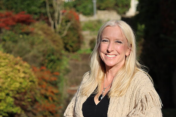 Roz Savage MP smiling with greenery in background