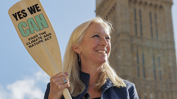 Roz Savage holding a Yes we CAN oar in front of Parliament